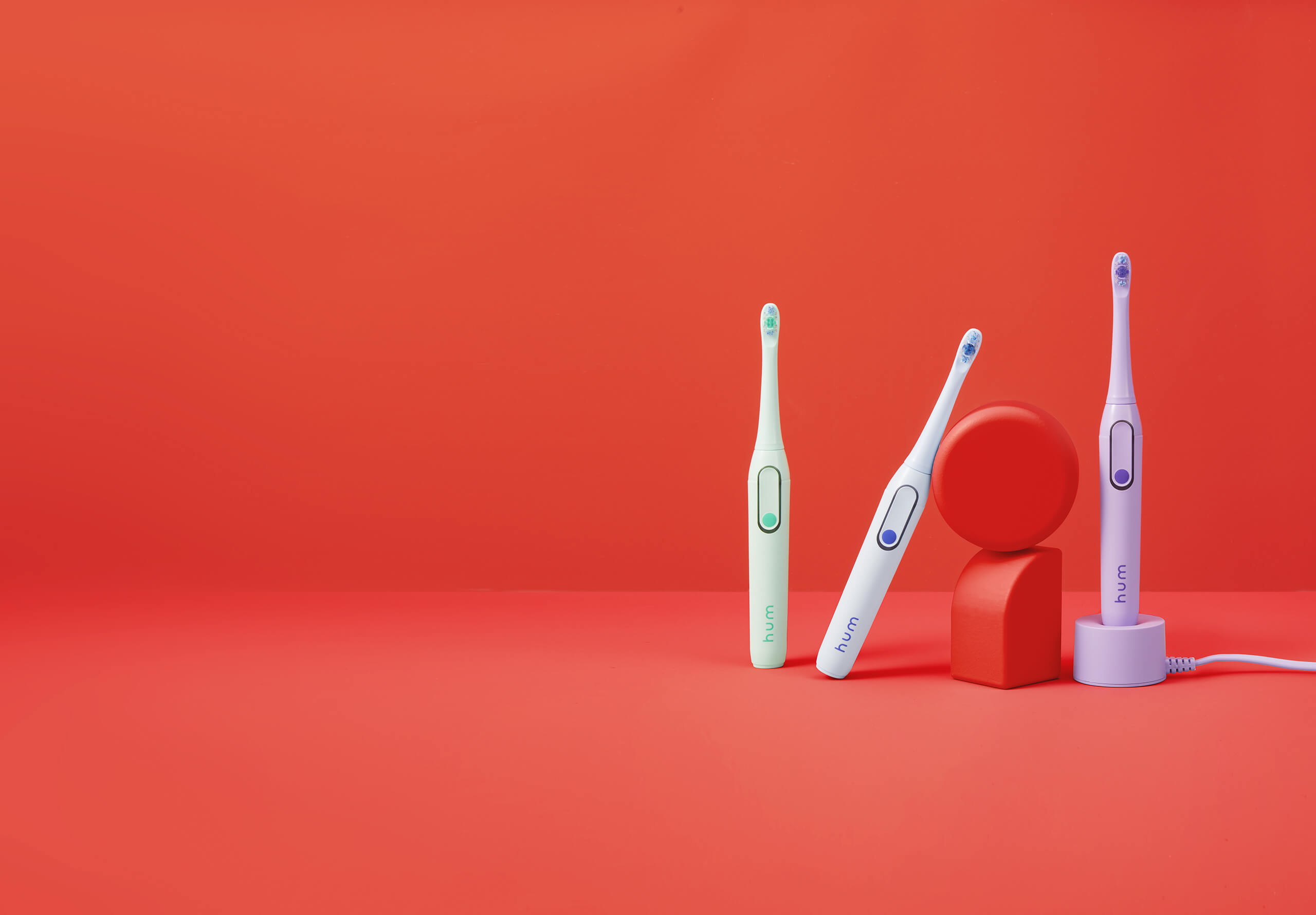 Three hum electric toothbrushes standing next to each other.