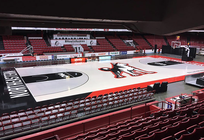 Basketball court with husky logo in the middle.